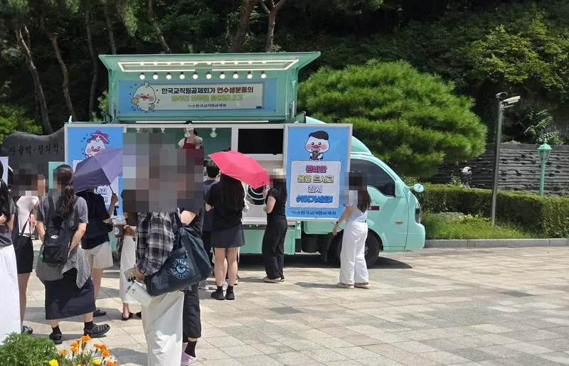 민트색 커피투어트럭 앞에 양산을 든 연수생들이 길게 줄 선 모습