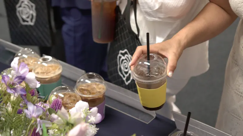 노란 슬리브 음료를 집는 손