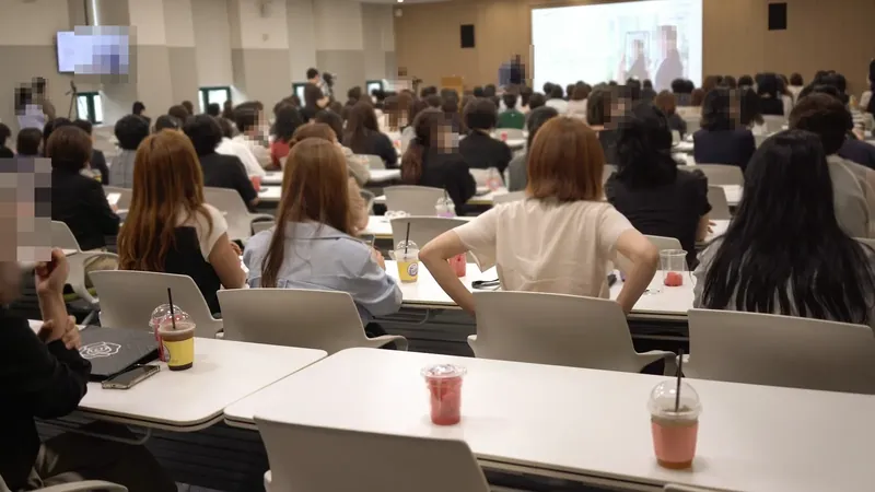 음료를 받은 참석자들로 가득 찬 세미나 강당