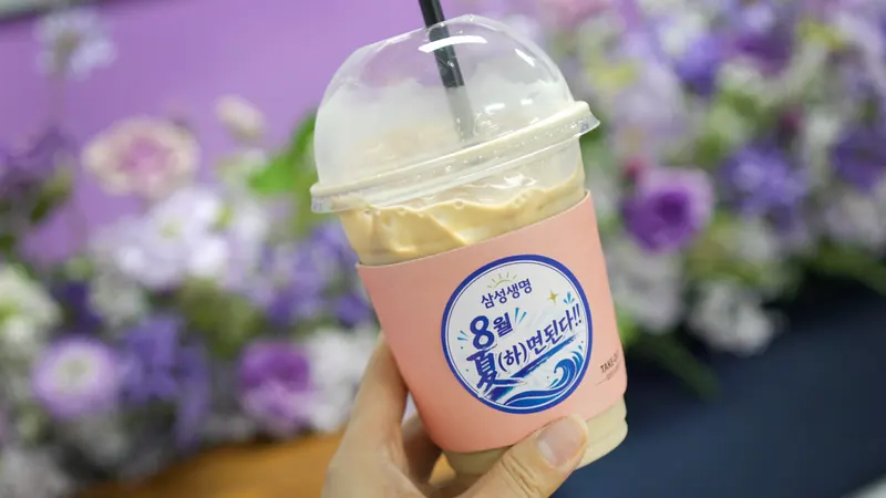 맞춤 스티커를 붙인 분홍 슬리브 아이스 음료