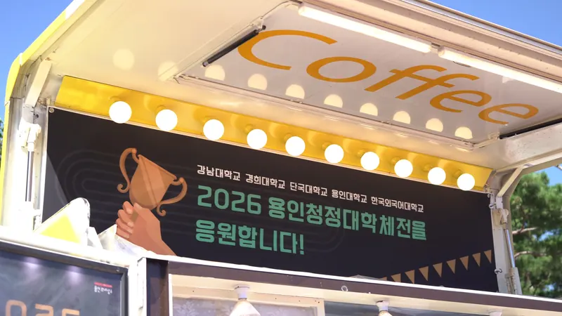 전구 조명과 행사 현수막을 단 노란 트럭 윗부분